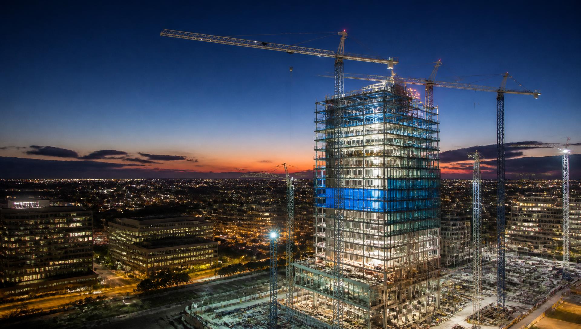 Modern skyscraper under construction at dusk